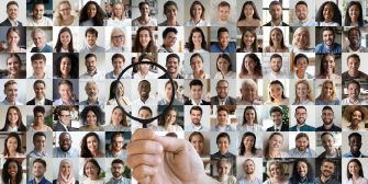 A hand holding a magnifying glass over a collage of diverse faces, symbolizing people search websites and the pursuit of personal information.