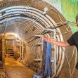 A man gesturing enthusiastically inside a renovated missile silo, showcasing its interior features. A man gesturing enthusiastically inside a renovated missile silo, showcasing its interior features.