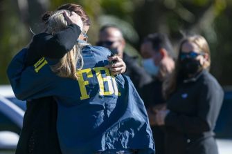 Two FBI agents embrace in a moment of mourning following a violent shootout in Sunrise, Florida.
