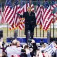 Former President Donald Trump speaking at a rally with American flags in the background. Former President Donald Trump speaking at a rally with American flags in the background.