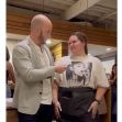 A man hands a large tip to a waitress at a restaurant as the two share a moment of gratitude. A man hands a large tip to a waitress at a restaurant as the two share a moment of gratitude.