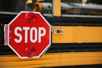 Stop sign on a school bus with red lights activated.
