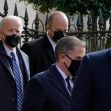 President Biden and advisors walking outdoors, all wearing masks. President Biden and advisors walking outdoors, all wearing masks.