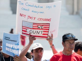 A group of protesters holding signs advocating for the counting of all residents in the U.S. census, emphasizing the importance of including non-citizens.