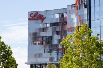 The Eli Lilly headquarters building with clear skies and trees in the foreground.
