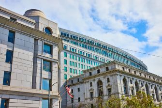 Image of the California Supreme Court building, showcasing its architecture against a cloudy sky.