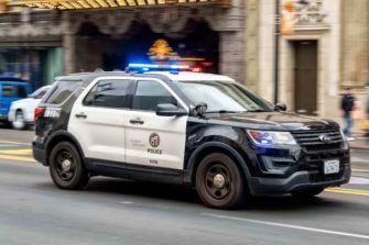 A Los Angeles police vehicle with its lights on, driving through the city.
