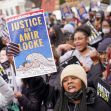 A group of protesters holding signs demanding justice for Amir Locke during a rally. A group of protesters holding signs demanding justice for Amir Locke during a rally.