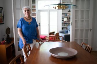 A woman stands in her home, reflecting on her successful lawsuit regarding the overwhelming smell of marijuana from her neighbor.