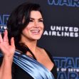 Gina Carano at a Star Wars event, smiling and waving. Gina Carano at a Star Wars event, smiling and waving.