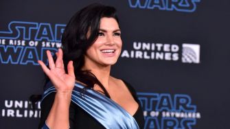 Gina Carano at a Star Wars event, smiling and waving.