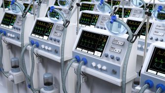 Row of ventilators displaying medical data on screens, indicating their use in healthcare settings.