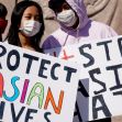 Two individuals holding protest signs that read "Protect Asian Lives" and "Stop Asian Hate" at a rally. Two individuals holding protest signs that read "Protect Asian Lives" and "Stop Asian Hate" at a rally.