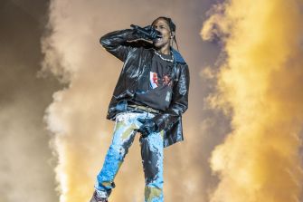 Travis Scott performing at the Astroworld Festival amid dramatic stage effects.