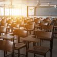 Empty classroom with wooden desks and chairs, sunlight streaming in from the windows. Empty classroom with wooden desks and chairs, sunlight streaming in from the windows.