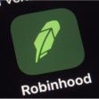 logo for the Robinhood app on a smartphone in New York. The online trading platform Robinhood is moving to restrict trading in GameStop and other stocks that have soared recently due to rabid buying by smaller investors. (AP Photo/Patrick Sison)