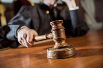 A judge holding a gavel in a courtroom setting.