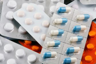 Assorted blister packs of prescription and over-the-counter medications, including tablets and capsules.