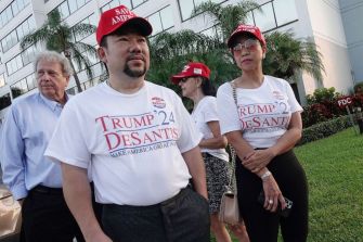 Supporters of Florida Governor Ron DeSantis at a voting reform bill signing event, wearing "Trump 24 Desantis" shirts and hats.