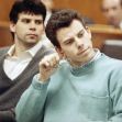 Two men, seated in a courtroom setting, appear deep in thought as they await proceedings related to their high-profile case. Two men, seated in a courtroom setting, appear deep in thought as they await proceedings related to their high-profile case.