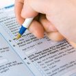 A close-up of a hand writing on a U.S. census form with checkboxes and demographic questions. A close-up of a hand writing on a U.S. census form with checkboxes and demographic questions.