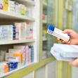 A pharmacist examining medication boxes in a pharmacy setting. A pharmacist examining medication boxes in a pharmacy setting.