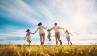 A family walking hand in hand in a sunny field, symbolizing unity and togetherness.