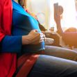 Pregnant woman seated on an airplane, showing a focus on her belly while wearing casual attire. Pregnant woman seated on an airplane, showing a focus on her belly while wearing casual attire.