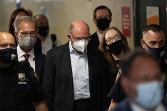 Allen Weisselberg, CFO of the Trump Organization, appears in court surrounded by law enforcement and legal representatives amid allegations of tax fraud and other charges.