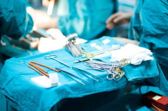 Surgical instruments arranged on a sterile table in an operating room.