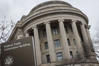 Federal Trade Commission Building with a sign indicating its purpose, set against a cloudy sky.