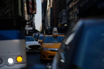 Traffic congestion on a busy New York City street with yellow taxis and other vehicles.