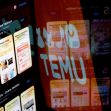 A reflection of the Shein and Temu apps displayed on a screen, illustrating the competitive landscape in online fashion retail. A reflection of the Shein and Temu apps displayed on a screen, illustrating the competitive landscape in online fashion retail.