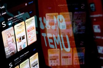 A reflection of the Shein and Temu apps displayed on a screen, illustrating the competitive landscape in online fashion retail.