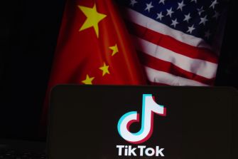 Logo of TikTok displayed in front of the flags of China and the United States.