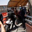 A group of individuals, including police officers, at a border crossing, as migrants prepare to cross into the United States. A group of individuals, including police officers, at a border crossing, as migrants prepare to cross into the United States.
