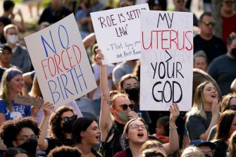 Protesters holding signs expressing their views on abortion rights during a demonstration.