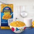 Image of a Kraft Macaroni & Cheese breakfast product, featuring a bowl of macaroni, a glass of milk, and an orange slice, against a kitchen backdrop. Image of a Kraft Macaroni & Cheese breakfast product, featuring a bowl of macaroni, a glass of milk, and an orange slice, against a kitchen backdrop.