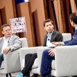 Elon Musk and Sam Altman participate in a discussion at a summit, with another speaker present. Elon Musk and Sam Altman participate in a discussion at a summit, with another speaker present.