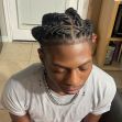 A Black teenager with twisted braids wearing a gray t-shirt and silver chain, sitting in a chair with eyes closed. A Black teenager with twisted braids wearing a gray t-shirt and silver chain, sitting in a chair with eyes closed.